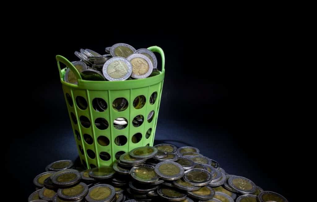 Green basket overflowing with coins