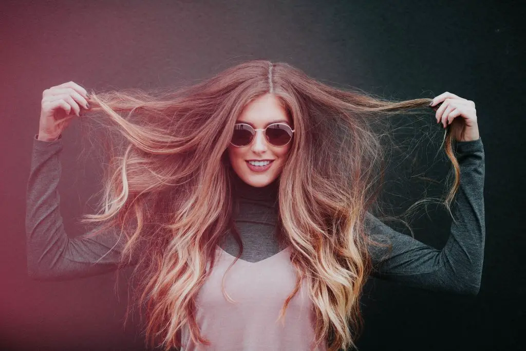 girl holding her hair with an eyeglass