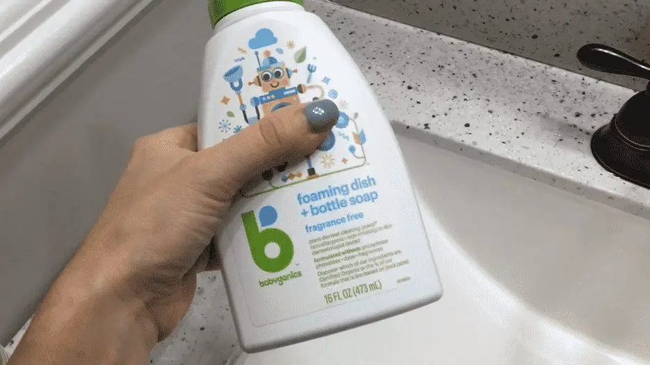 Person holding a bottle of Babyganics