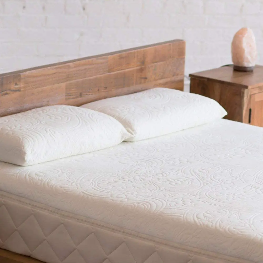 Bed with two pillows and a wooden headboard