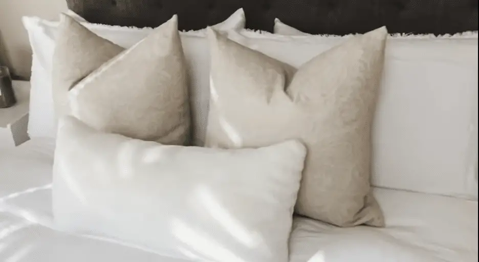 Bed with three pillows and white sheets.