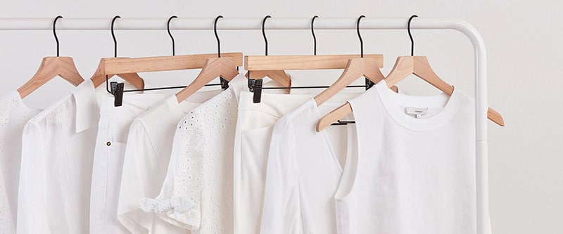 row of white clothes on hangers.
