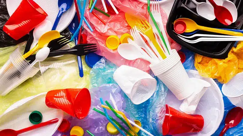 Pile of disposable plastic cutlery and straws