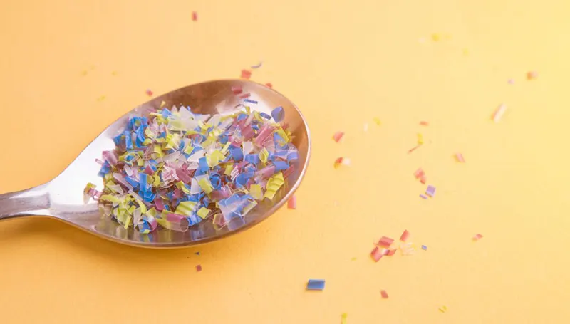 Plastic-filled spoon on yellow