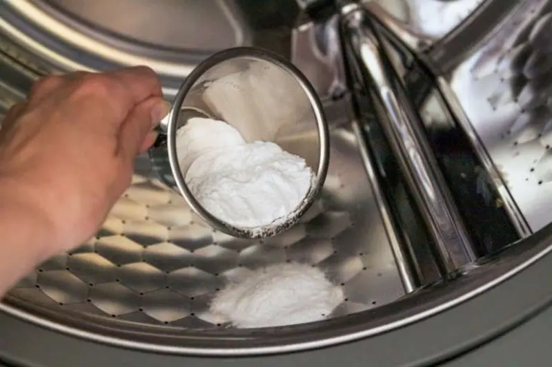 Person adds baking soda to washer.