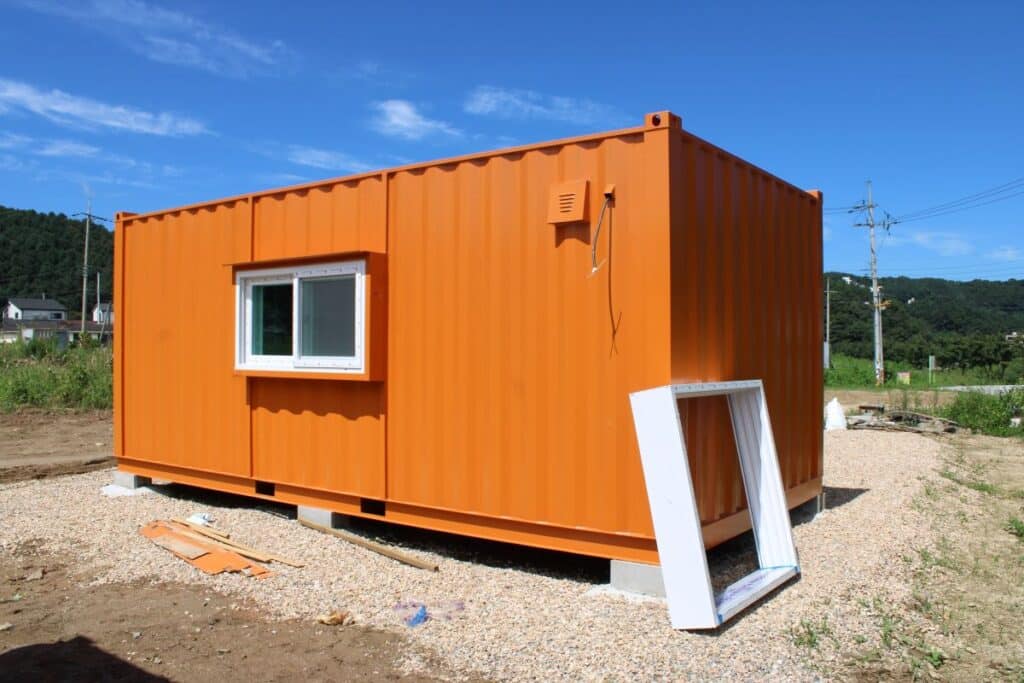 Orange shipping container on dirt ground
