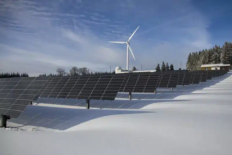 Wind turbine and solar panels in snow