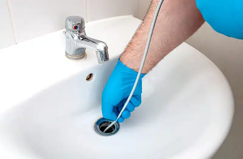 Person inserting Plumbing snake