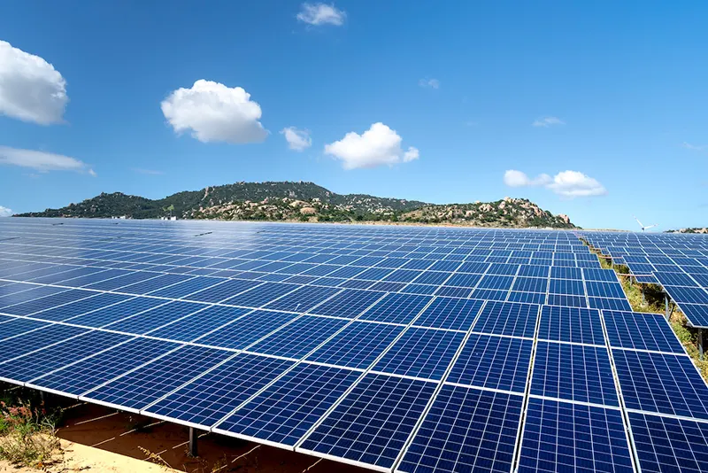 Field of solar panels with mountains in the background