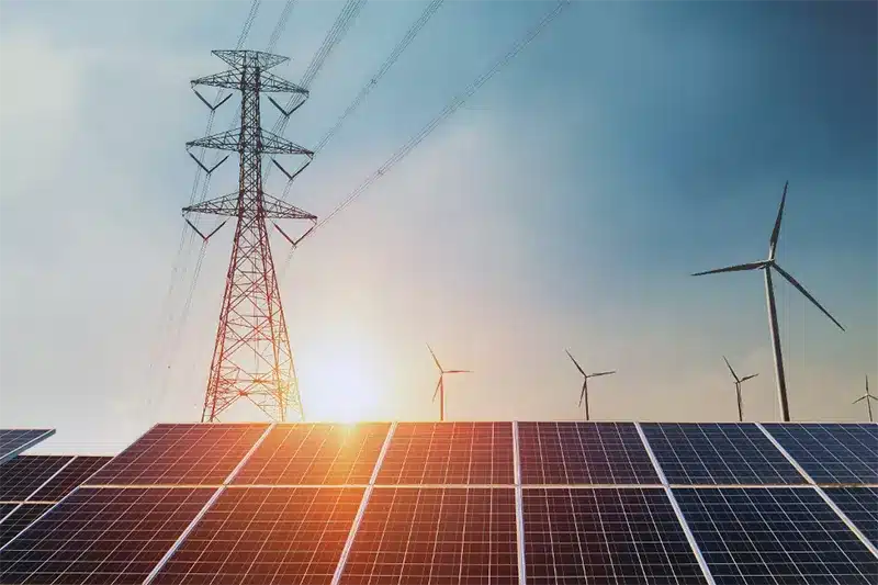 Solar panels, wind turbines, and a power tower in a field