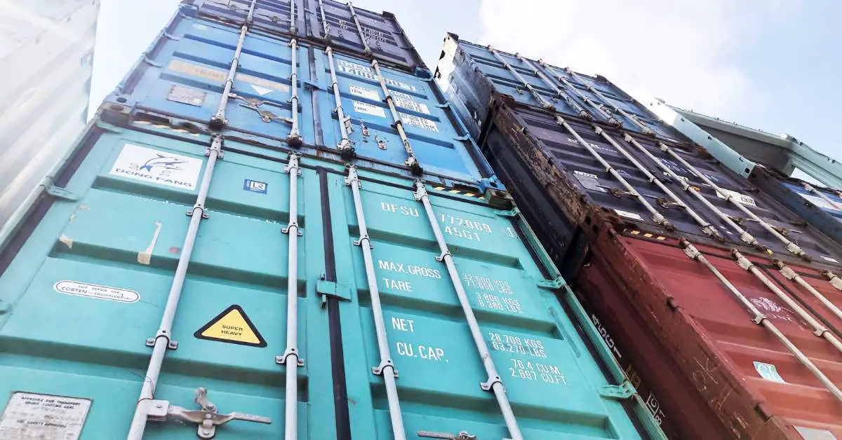 two vertical stacks of three shipping containers each, aligned neatly atop one another