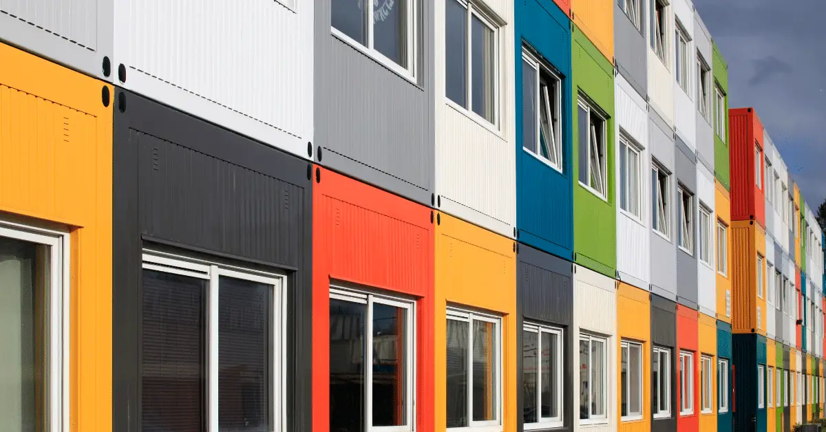 row of vibrant two-story shipping container homes, each showcasing unique colors and designs