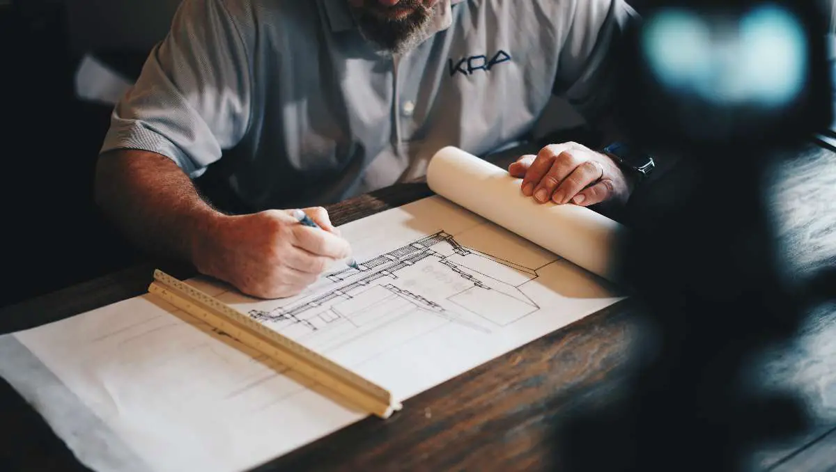 An architect making a blueprint design of a container home. 