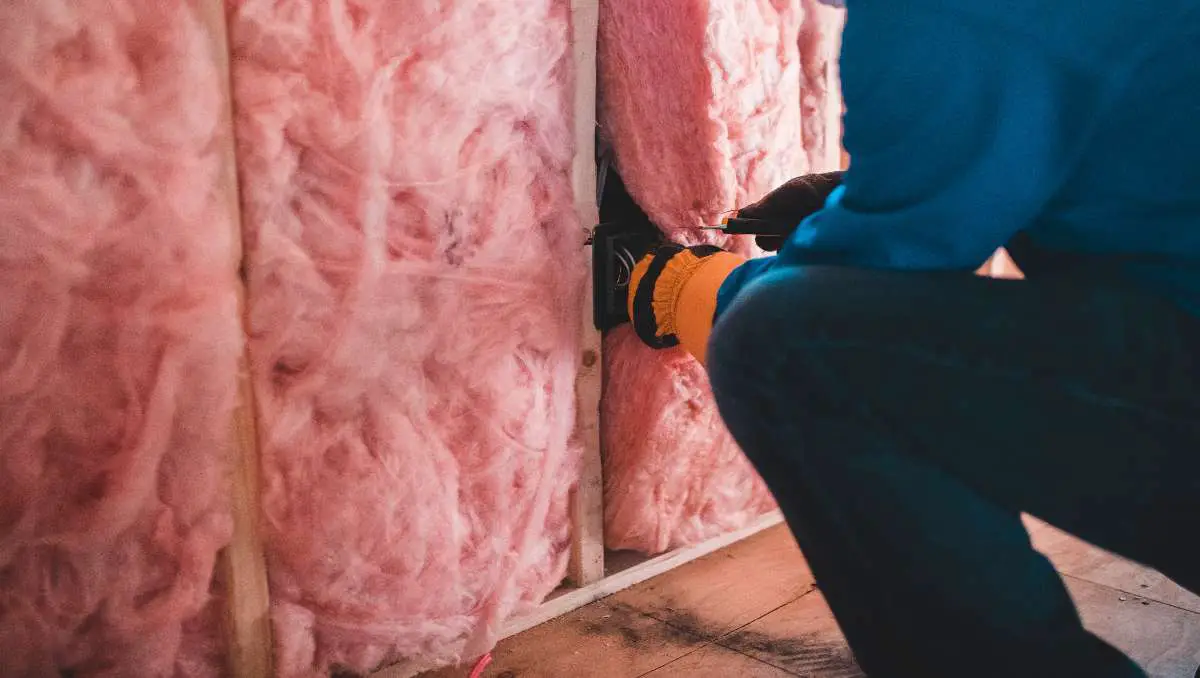 A construction worker doing insulation in a container house.