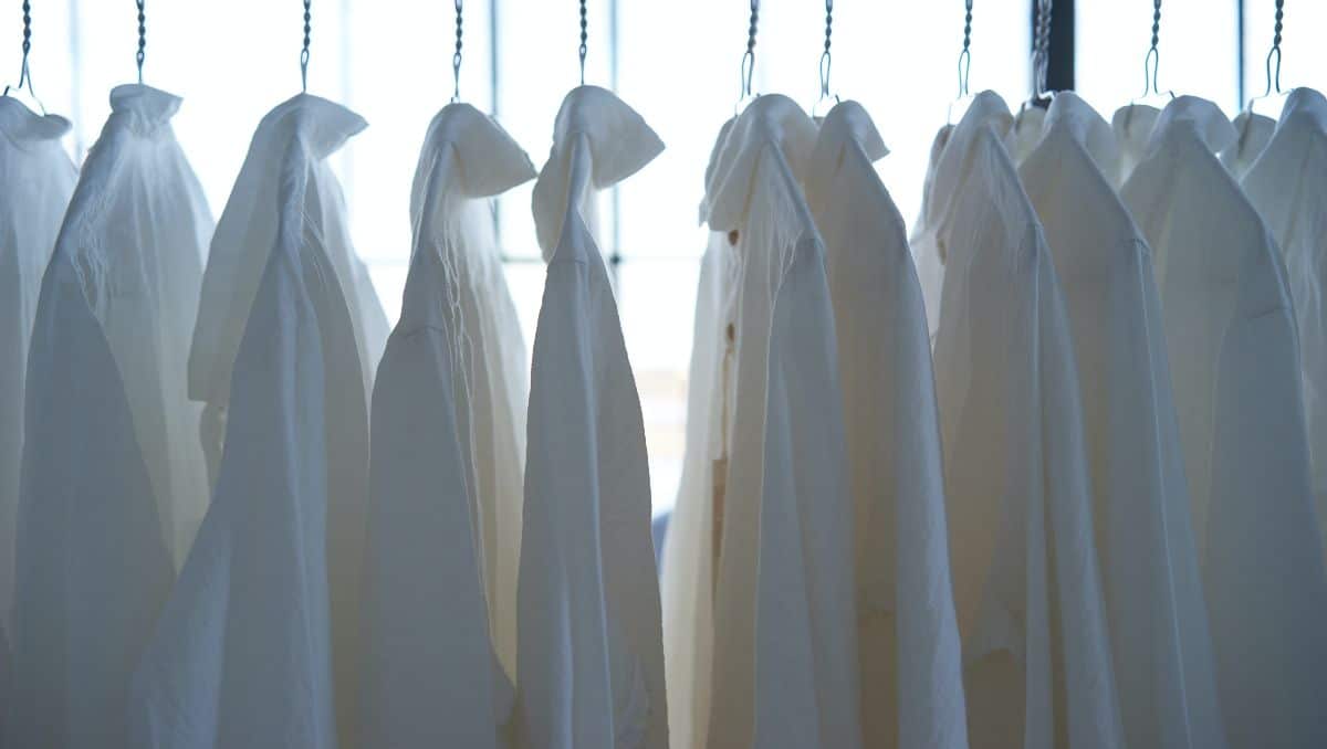 A line of white polos being hanged and air-dried.