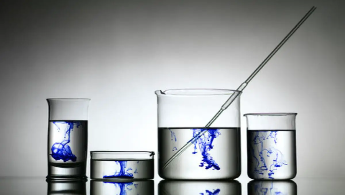A group of beakers with different sizes and shapes filled with blue liquid. 
