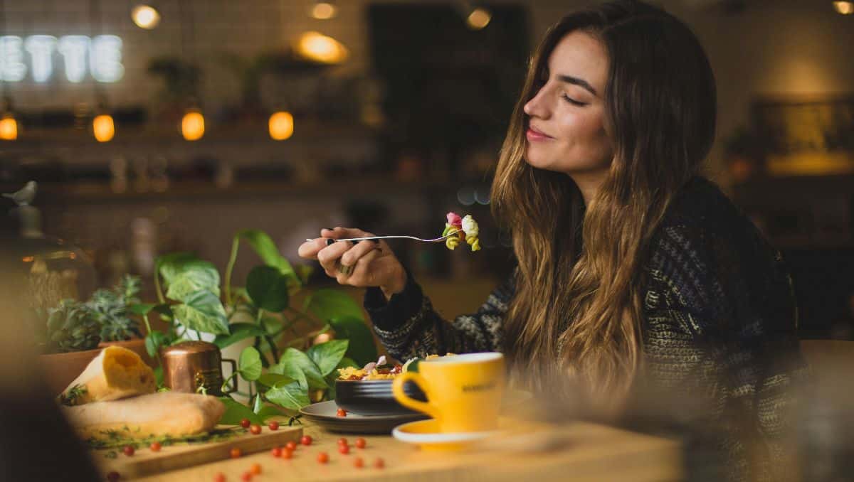 A woman eating and savoring her salad.