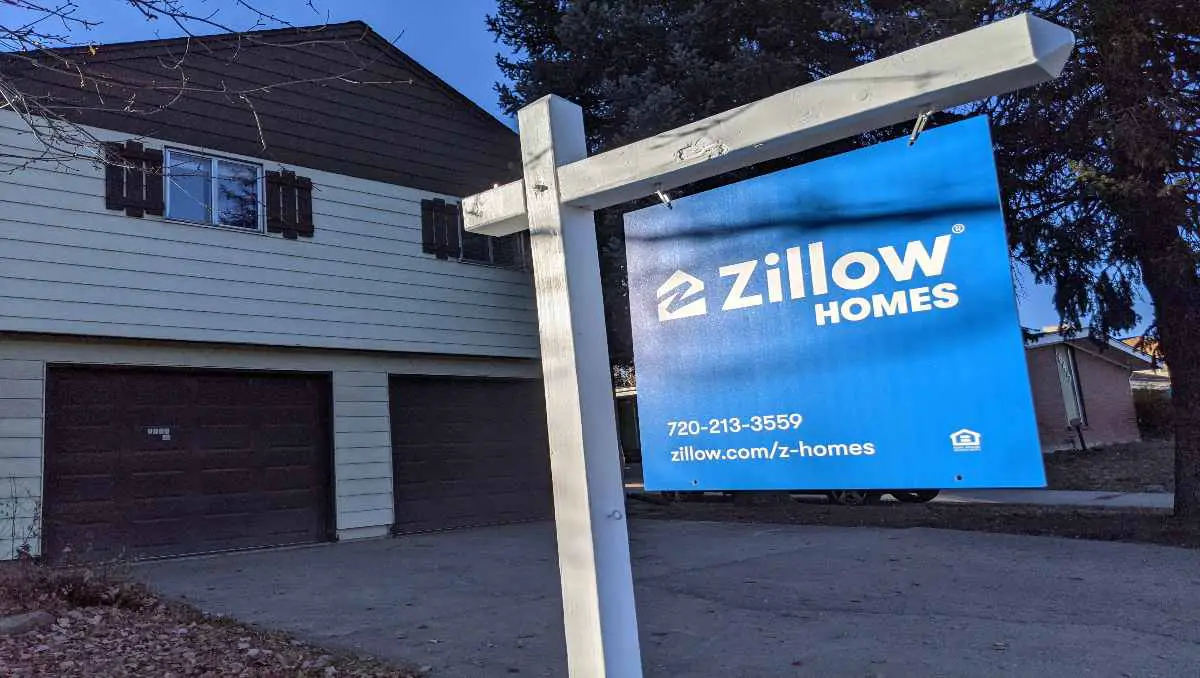 The Zillow homes sign in front of a house. 