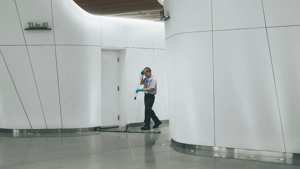 A man cleaning on the floor inside a building.