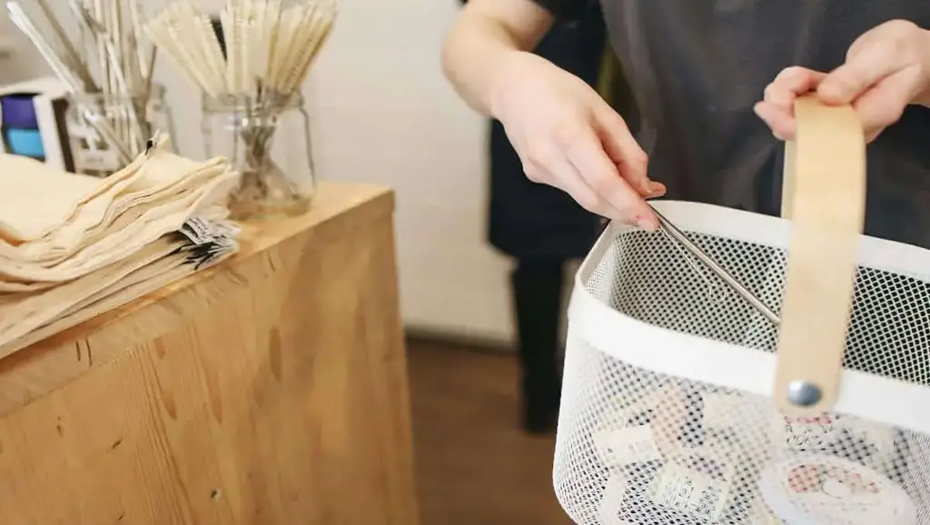 A girl putting recyclables in a basket.